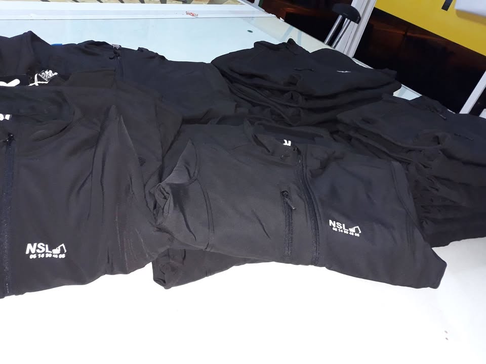 Desenvolvimento de têxtil de trabalho estampado e bordado e esferográficas promocionais.