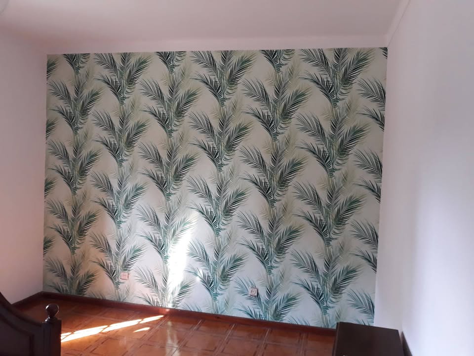 Decoração de parede de quarto de uma moradia com impressão de motivos.